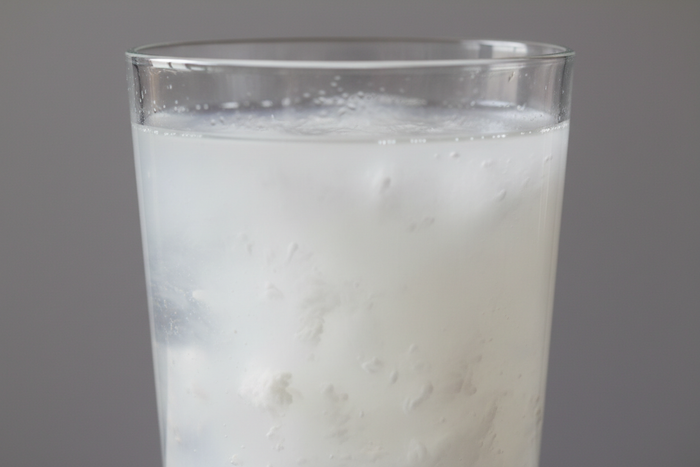 drinking glass of water with murky white chlorine water